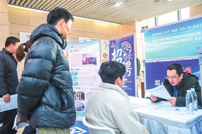 招聘人员为求职者答疑解惑。兰州新区报记者魏晓倩 摄