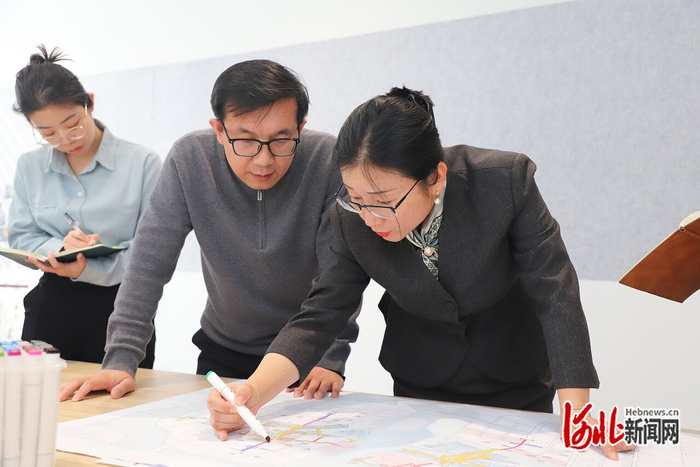 日前，夏雨（右一）与同事们一起商量规划细节。 雄安城市规划设计研究院供图