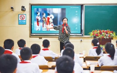 在“非遗进校园”活动中，刘宇给孩子们讲解德州窑红绿彩文化和技艺。陈庆辉摄