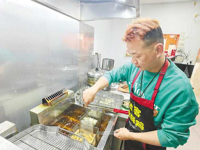 位于江汉区北湖正街的“台客盐酥鸡”店内，潘佳辉正在专心制作炸品。 （湖北日报全媒记者 张倩倩 摄）