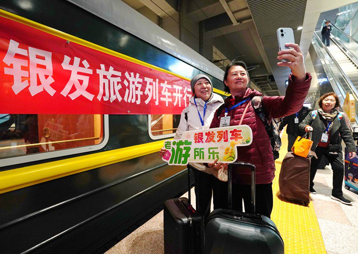 3月15日，在北京丰台站，游客和2025年京津冀首趟银发旅游列车合影留念。 新华社记者张晨霖 摄