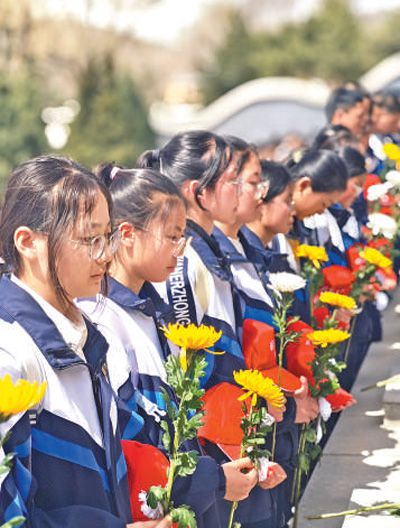 固原二中学生手拿菊花默哀。人民网记者 宽 容摄