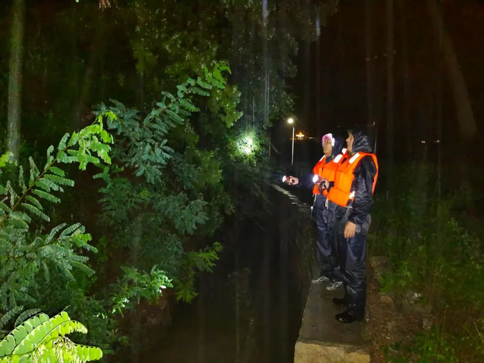 “护渠人”张学义与同事下雨天在红旗渠畔巡查