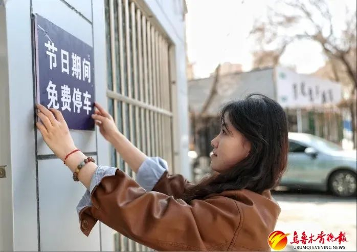 4月3日，在沙依巴克区平顶山街道停车场，工作人员在张贴节假日期间免费停车标识。