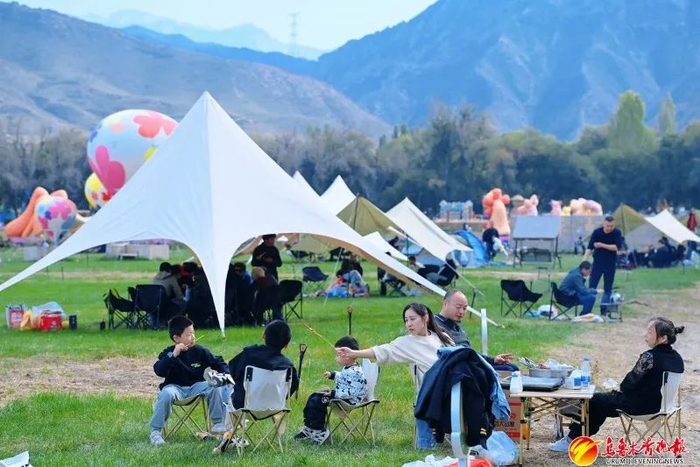 在水磨沟区石人农场景区，游客在露营区域休闲度假享受假期郊游生活。资料图片