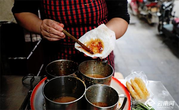 老板正在给油糕饵块涂抹酱料 资料图