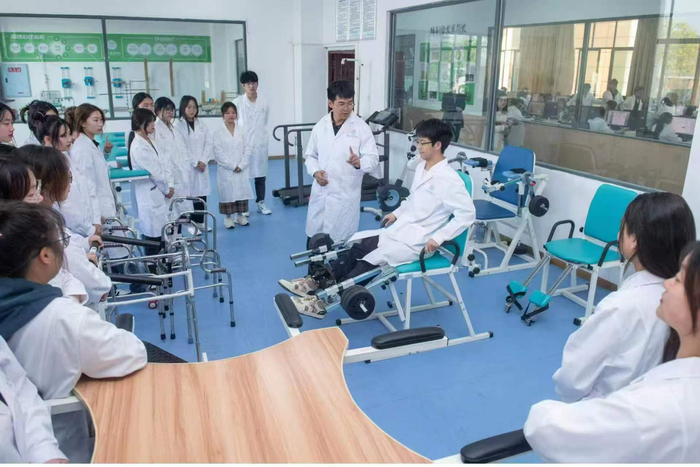 图：智慧健康养老专业的学生正在老师带领下学习推拿按摩技巧