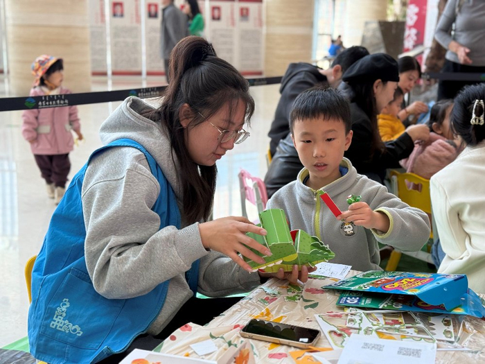  这是志愿者在与一名小朋友一起进行手工制作。（伊兰娜 摄）