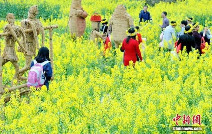  婺源油菜花田稻草扎制而成的农耕文化、卡通动物。卓忠伟 摄