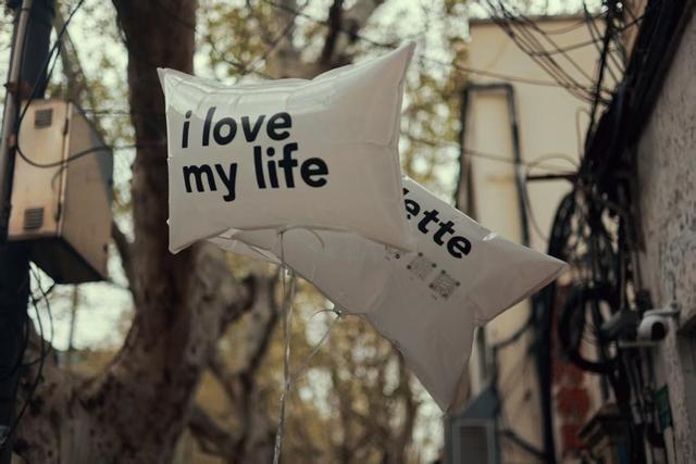 自行车后座系上了两只白色气球。金亮亮 摄