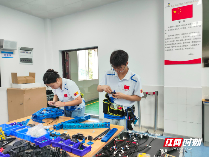 周贤亮（右）和他的队友在练习组装机器人。