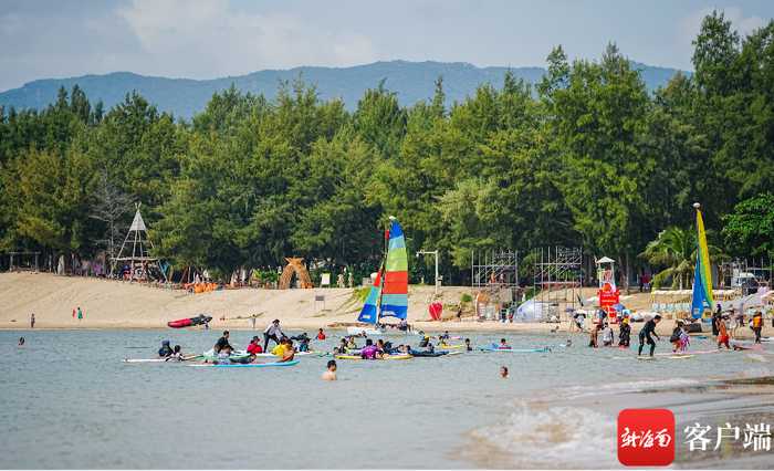 三亚后海村，游客在打卡游玩，体验冲浪。记者 李昊 摄