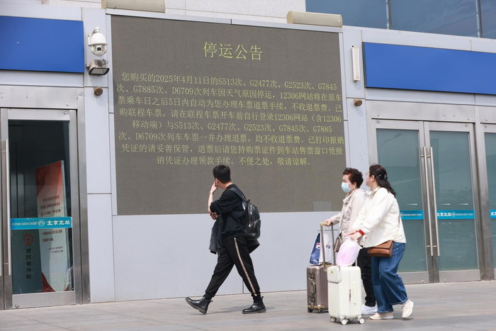 ▲4月11日，旅客在北京北站关注列车停运公告。图据视觉中国 中新社记者 贾天勇 摄
