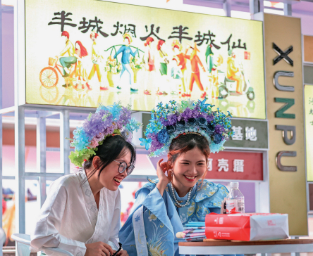 泉州东海街道蟳埔村，两名游客体验当地非遗项目“簪花围”。（林劲峰 摄）