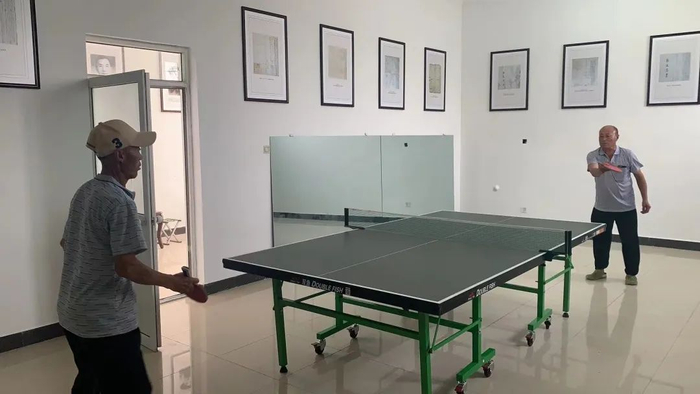 图：两个老人在上镇村文体活动室打球