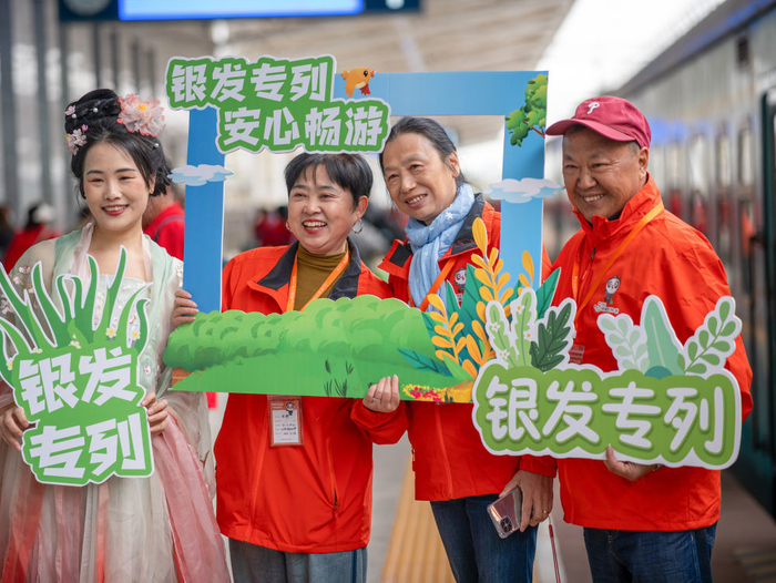 3月28日，在四川省成都市铁路安靖站，旅客们在上车前合影。新华社发（孟宽 摄）