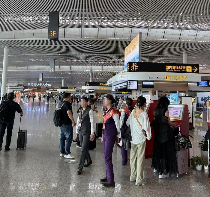重庆江北机场T3A航站楼内 仍有身着制服的推销人员在值机柜台附近卖卡