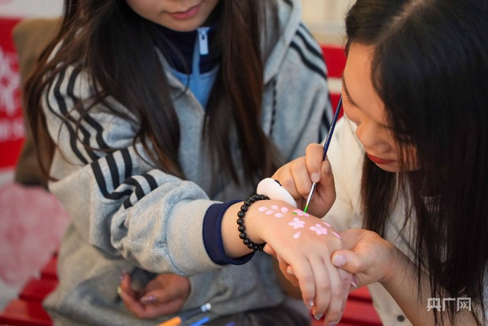 手工艺人为旅客现场演示传统花钿绘技法（央广网发  张羽涵  摄）