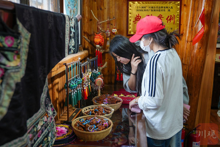 3月27日下午，来自山东的游客正在十八洞苗绣实践实习基地挑选产品。 摄影 吴聃