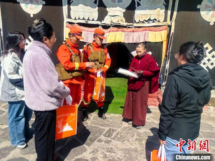  图为西藏森林消防总队队员进寺庙发放防火宣传手册。王治平 摄