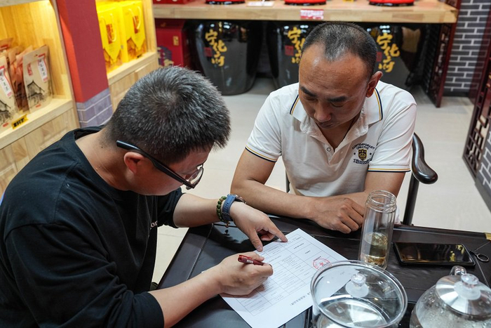 工作人员上门协助商户办理手续。雄安媒体中心刘潇 摄