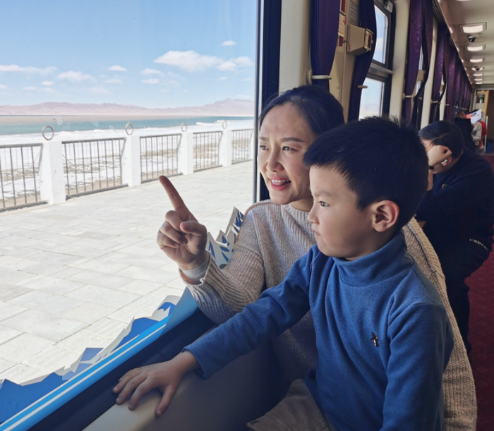 图为列车经过措那湖，旅客望向窗外的风景。通讯员 吴道洁 摄