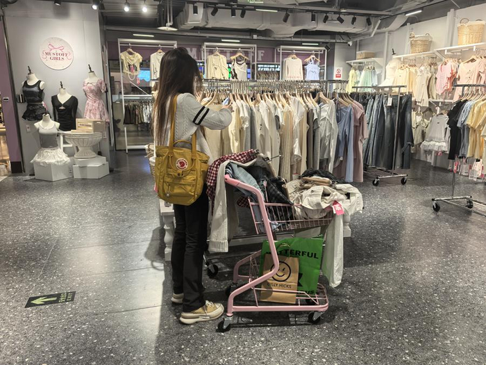 一名消费者一次性挑选了不少服饰。