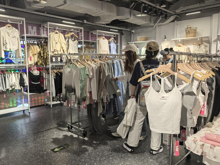 消费者正在MUSTOFF门店内选购服饰。