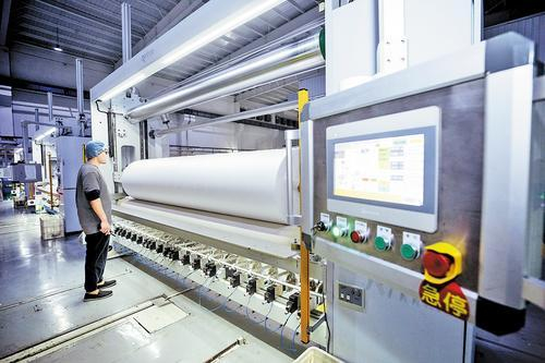     4月11日，在高阳县宏润新型面料有限公司，工人在对无纺布进行分切。 沈齐摄