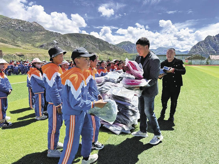 白虎升（右二）为学生捐赠学习用具。受访者供图