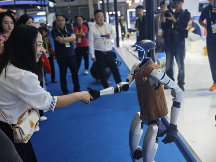 观展者与人形机器人进行互动。人民网记者 黄盛摄
