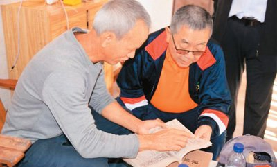 通过广西玉林“玉侨子午线”平台成功寻亲的侨胞与亲人查看族谱。“玉侨子午线”平台供图