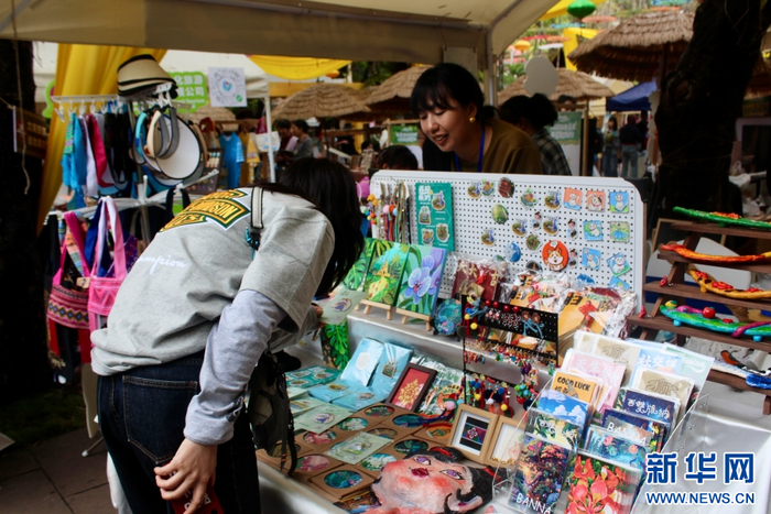   游客在文创摊位前挑选文创产品（4月13日摄）。新华网 和新兰 摄