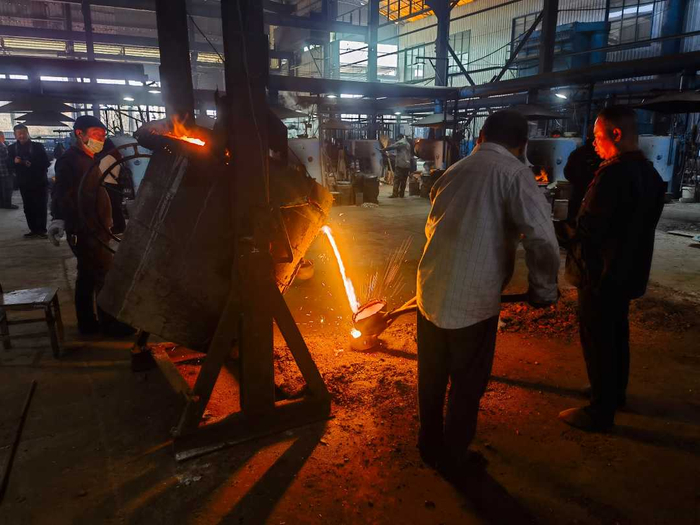 河南华邦电器炊具有限公司工人正在进行铁水提取作业。杜冠甲摄