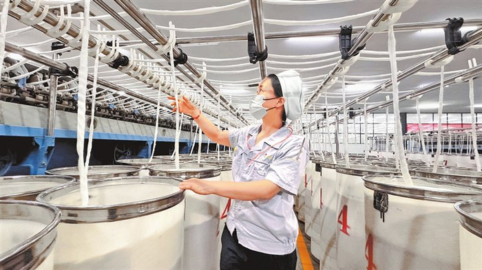 粗纱工序挡车工要小梦，在纺纱生产前纺车间忙碌。