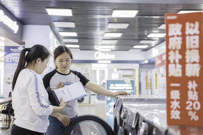 以旧换新政策激发中国消费活力。图为消费者16日在山东省聊城市的一家商场里选购家电。（视觉中国）