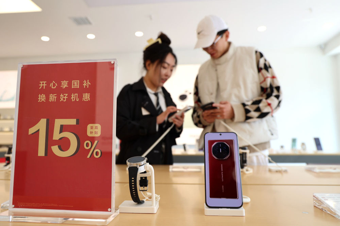 　　  4月10日，消费者在山东省滨州市一家手机商店内选购手机。新华社发（初宝瑞摄）