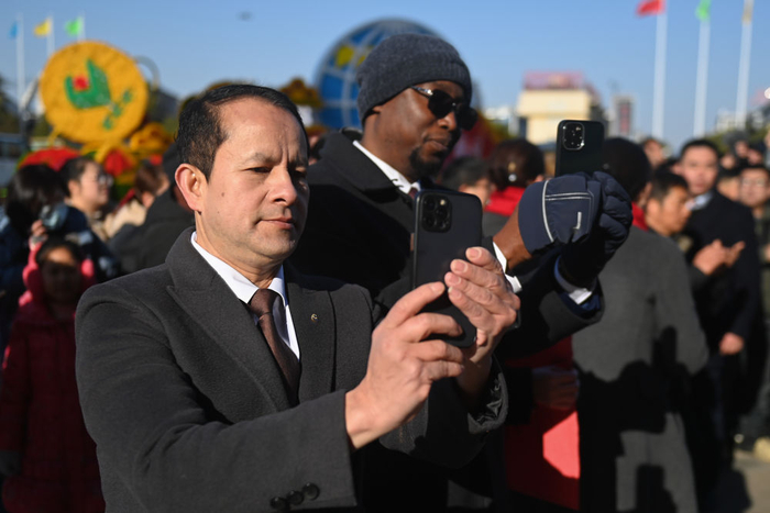 　　  来自尼泊尔的客商（左）在义乌国际商贸城观看开市仪式的舞龙表演（2025年2月9日摄）。新华社记者 黄宗治 摄