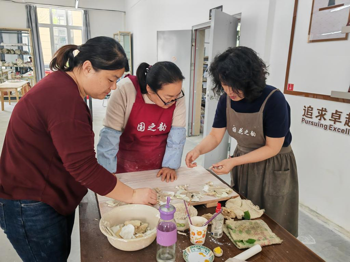   在牡丹区新经济产业园，刘翠英（右一）正指导手工匠人设计牡丹瓷文创产品。新华社记者刘铮 摄