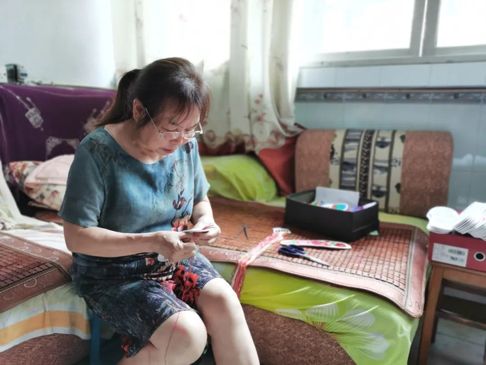 张兴会在家中缝制鞋垫。