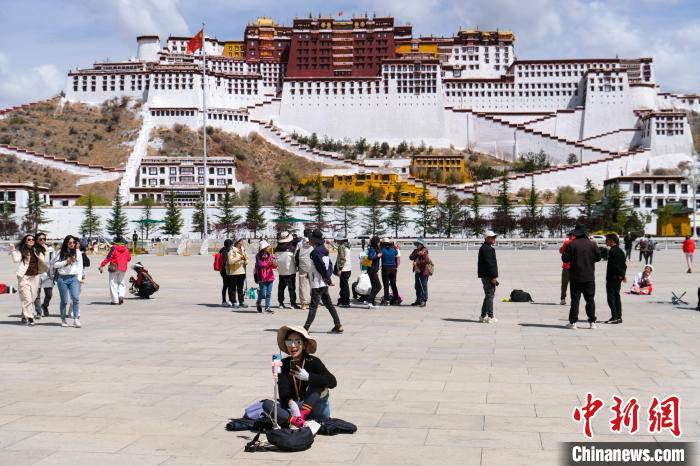 4月18日，一位视频博主在拉萨布达拉宫广场直播。　中新社记者　江飞波　摄