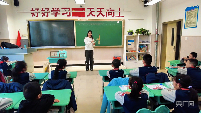 杨姗正在为学生讲解皮影  （央广网记者姜茸  摄）