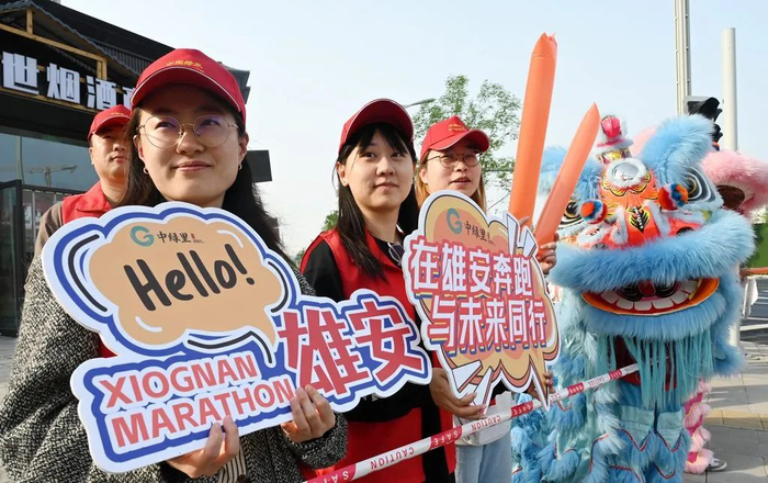 4月20日，2025雄安马拉松开赛。启动区赛道边上，“中绿里”志愿者们为选手加油。河北日报客户端记者 刘光昱 摄