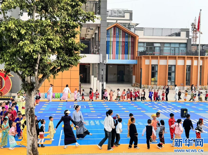 幼儿园教师带领学生及家长开展室外活动（资料图）。新华网发（遮岛镇中心幼儿园 供图）