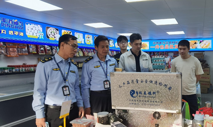 执法人员对经营户销售的水产品进行快检。