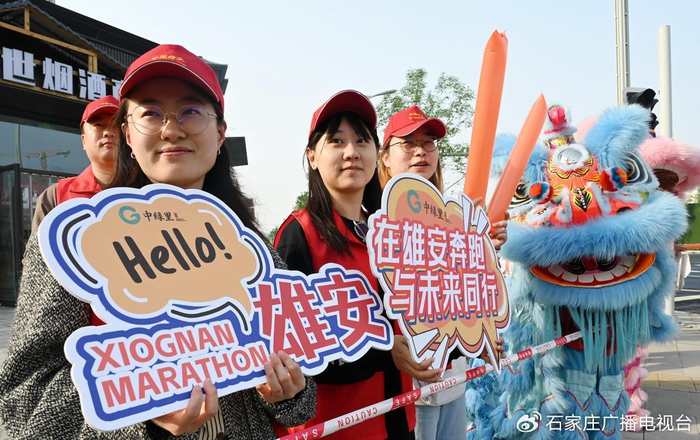 4月20日，2025雄安马拉松开赛。启动区赛道边上，“中绿里”志愿者们为选手加油。河北日报客户端记者 刘光昱 摄