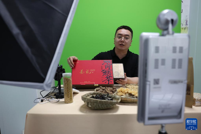陇南市康县铜钱镇干部赵永鑫在助农直播间用直播带货的方式推介康县茶叶（4月20日摄）。新华社记者 陈斌 摄