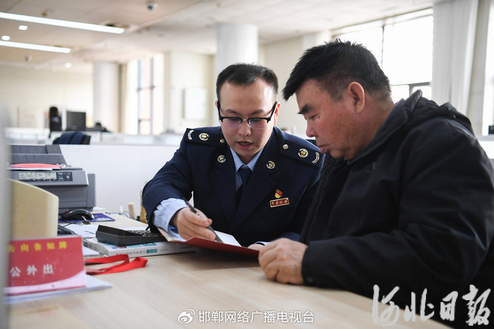 近日，在邯郸市政务服务中心大厅，工作人员和办事群众“肩并肩”办理业务。董源摄