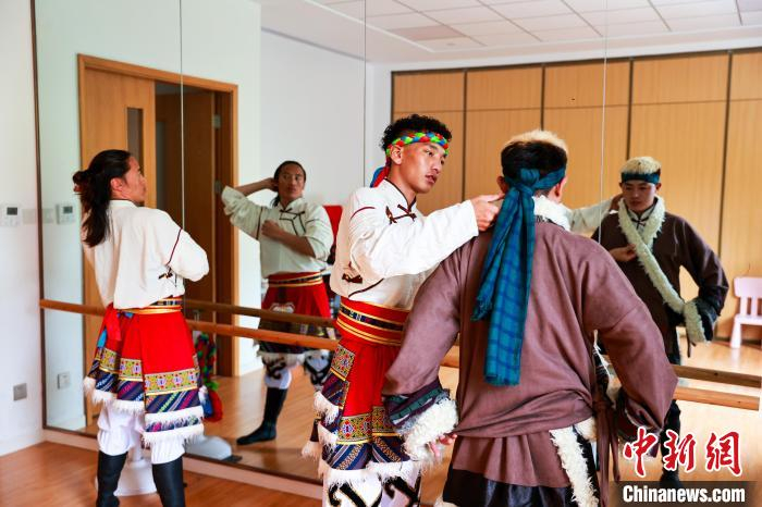  图为达日县演职人员上台前互相整理演出服。中新社记者 薛蒂 摄