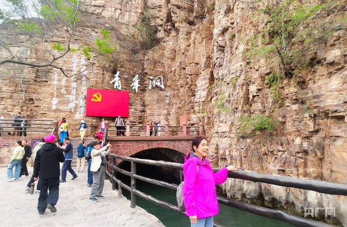 游客在红旗渠青年洞前拍照打卡（央广网记者  郝振青  摄）